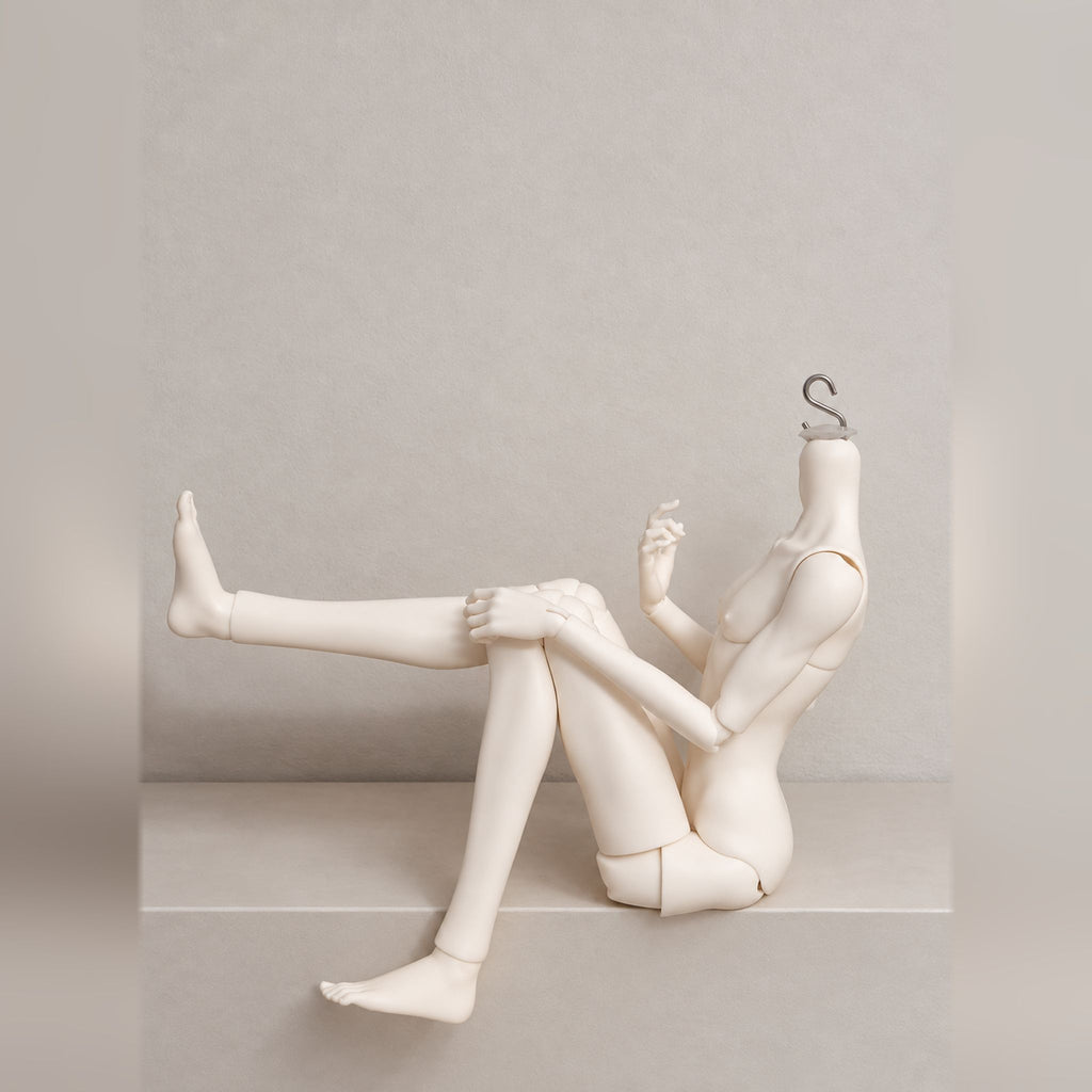 Poseable male BJD body with flexible hip and knee joints in a seated leg-lift pose
