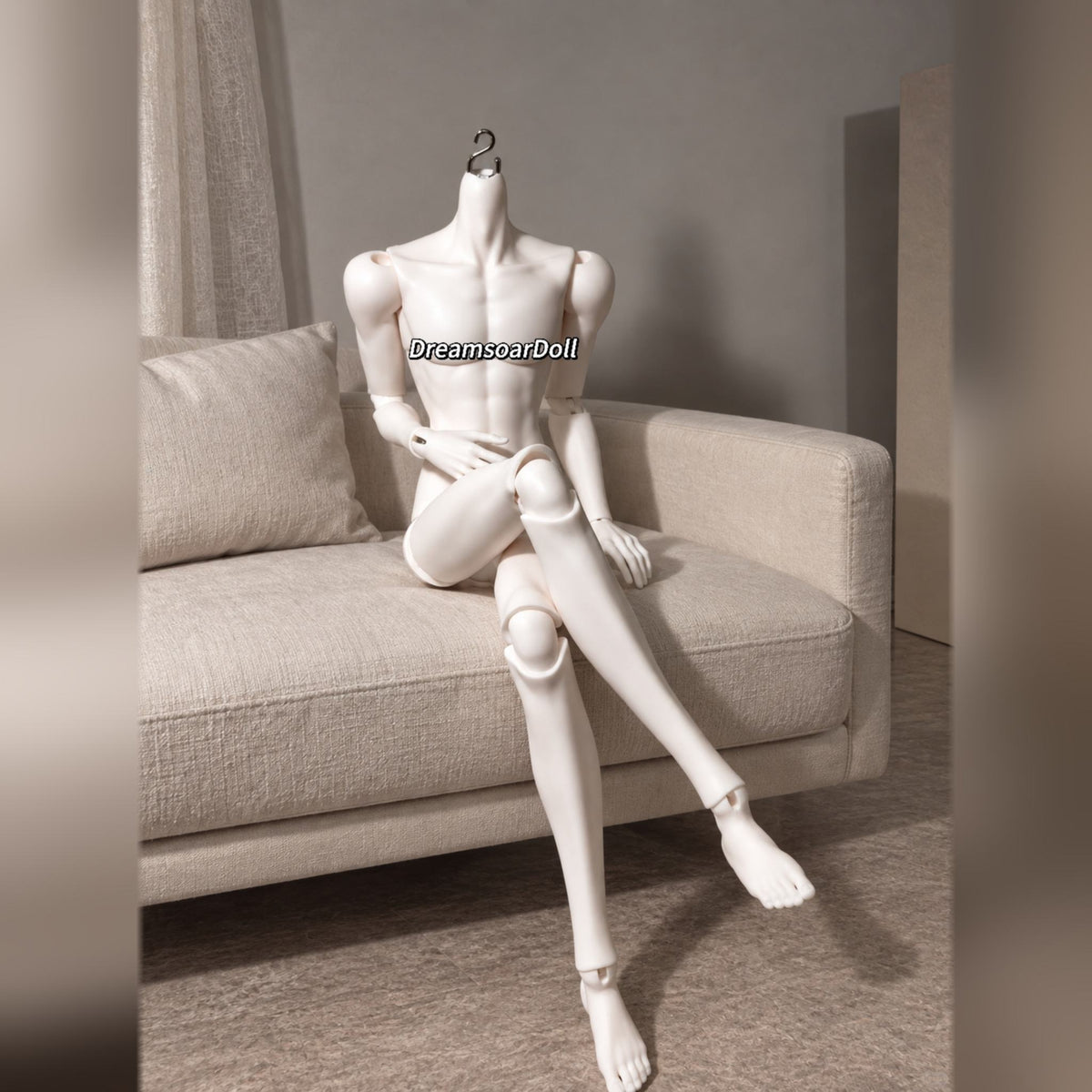 Articulated male BJD body seated with crossed legs to show flexible joints