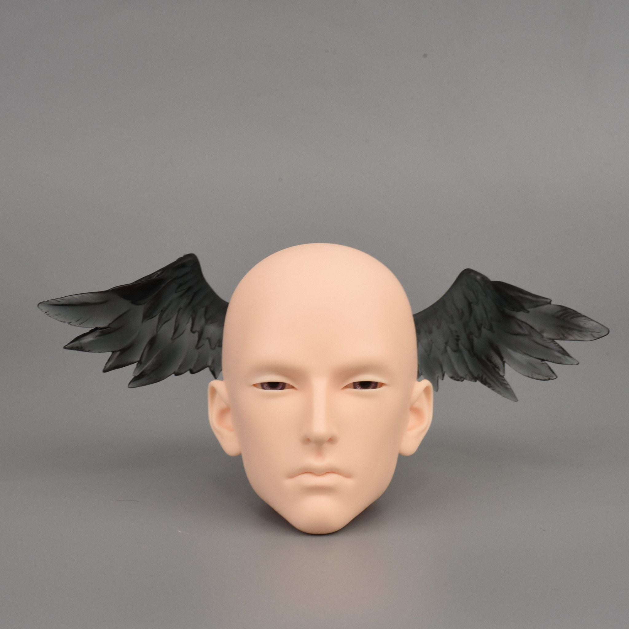 Black BJD doll angel wings accessory attached to resin doll head for fantasy character customization