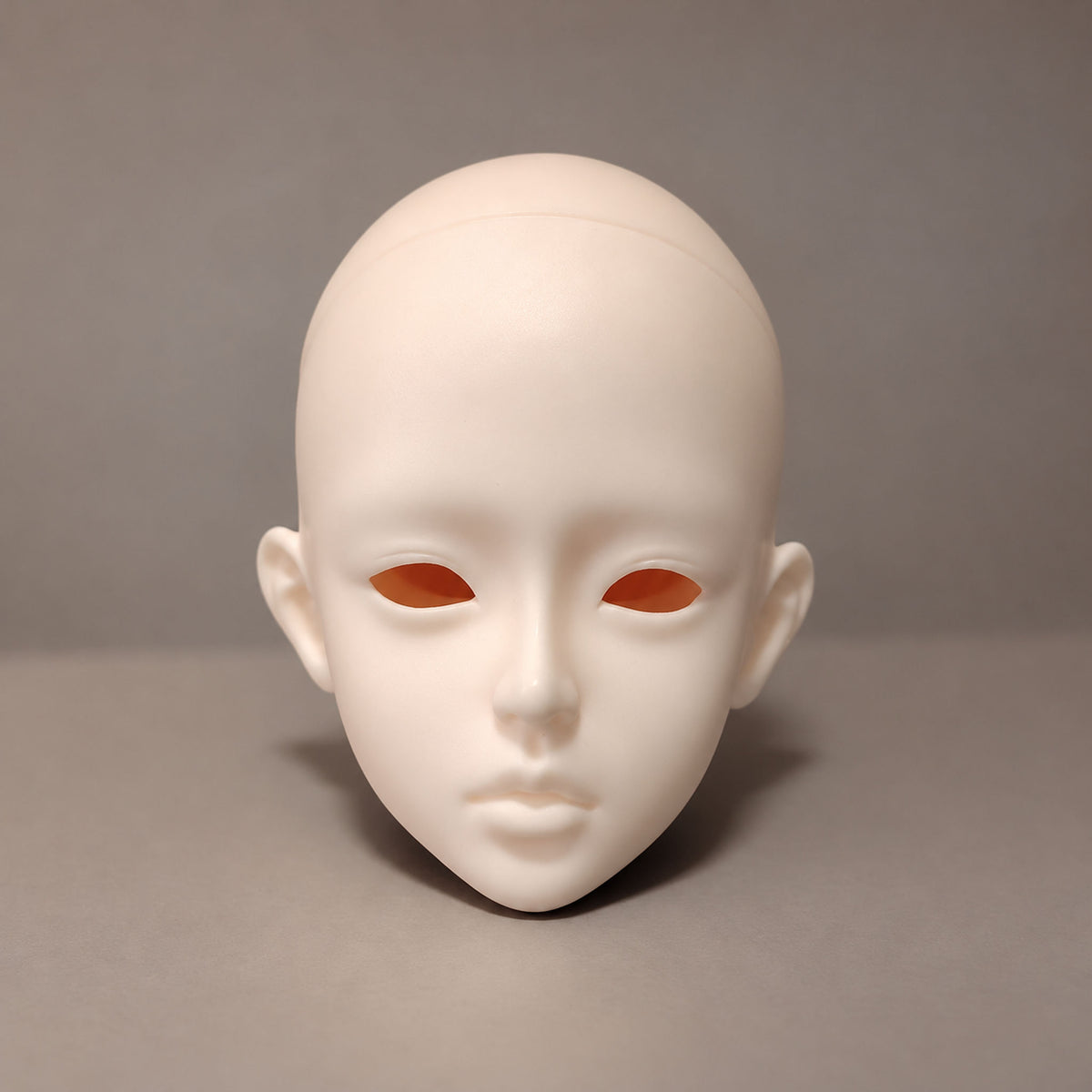 Unpainted female BJD head sculpt with almond-shaped eye openings, a petite nose and softly defined full lips