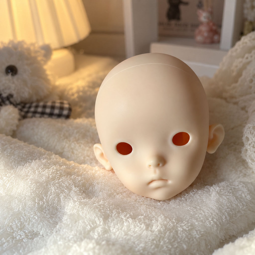 Unpainted 1/6 scale BJD head with a rounded childlike face, large eye openings, a tiny nose and softly parted lips