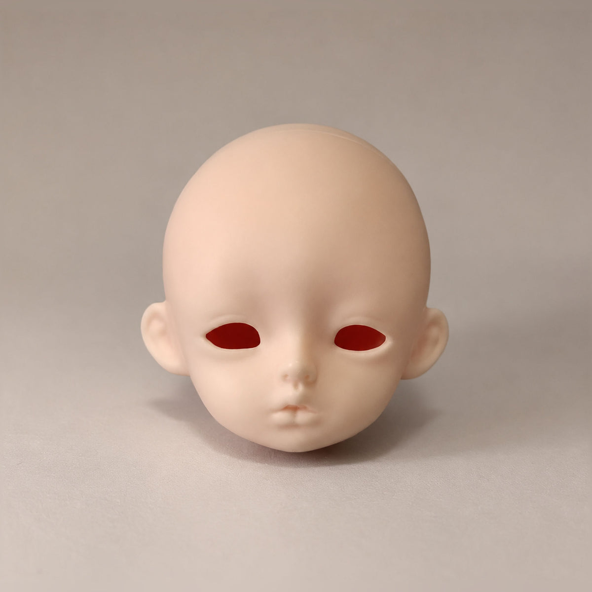 Unpainted girl BJD head with large almond-shaped eye openings and softly parted lips