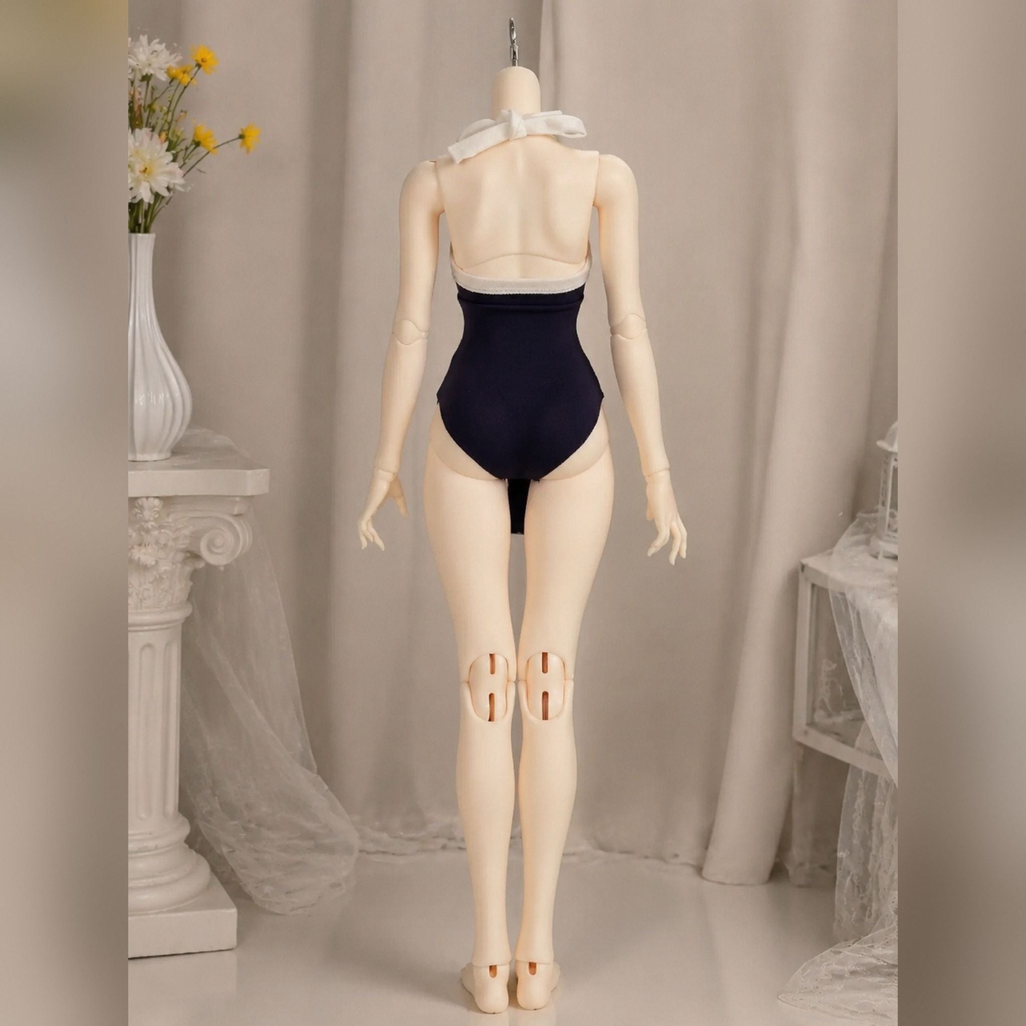 Female BJD doll body wearing a one-piece swimsuit back view showing back sculpt and joint structure
