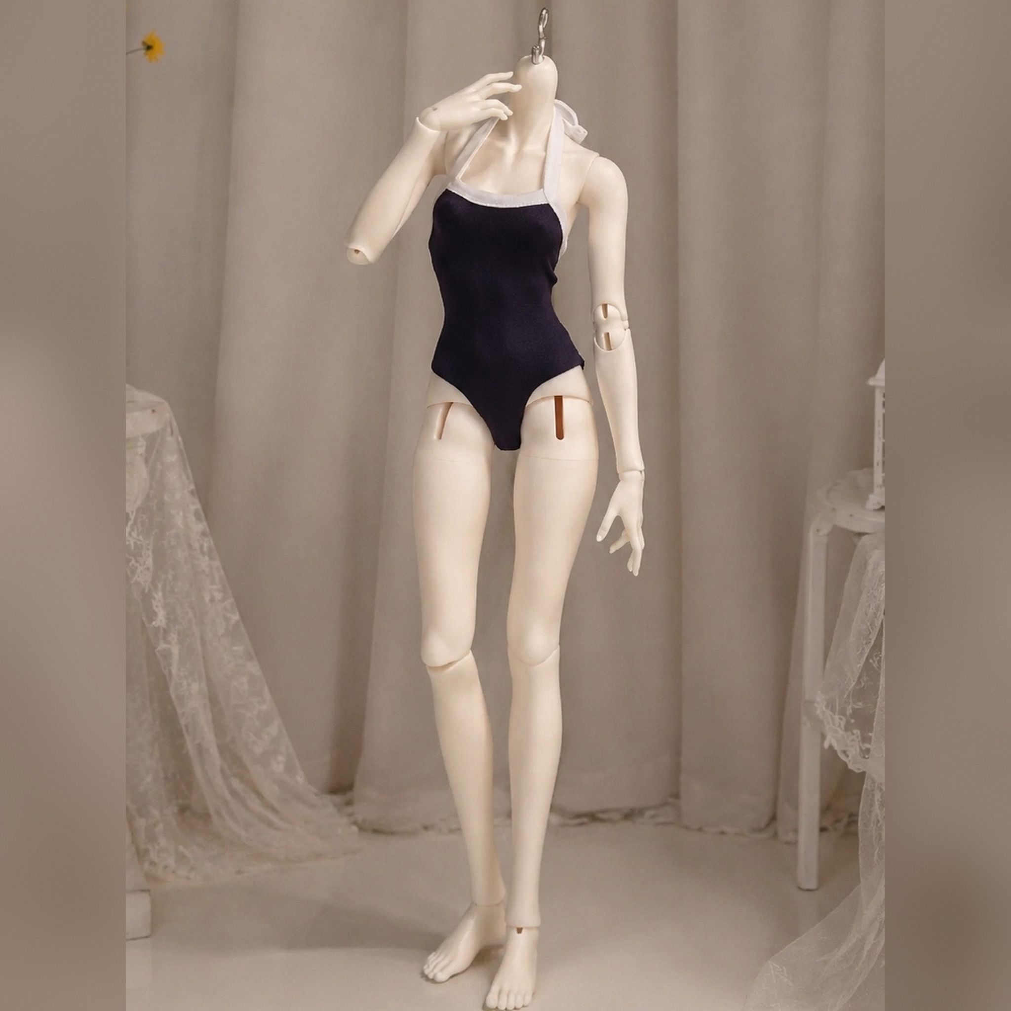 Female BJD doll body standing in a one-piece swimsuit demonstrating poseability and slim body proportions
