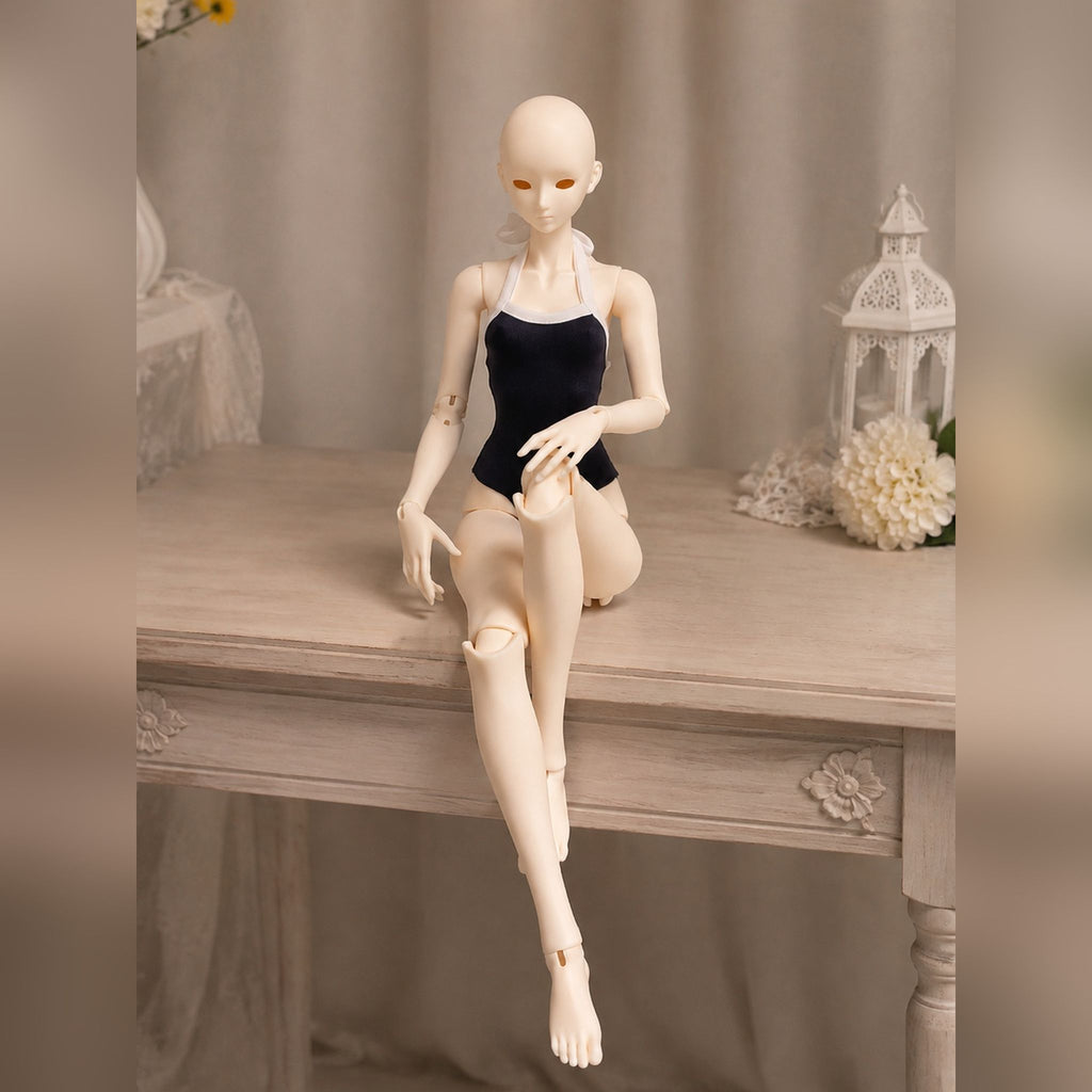 Female BJD doll body seated on a tabletop demonstrating natural sitting pose and joint flexibility